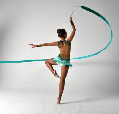 Mavi takımlı bir jimnastikçi dans ediyor.