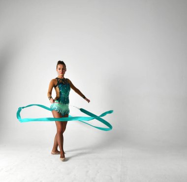 Mavi takımlı bir jimnastikçi dans ediyor.