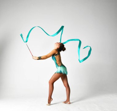 Mavi takımlı bir jimnastikçi dans ediyor.