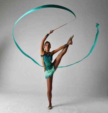 Mavi takımlı bir jimnastikçi dans ediyor.