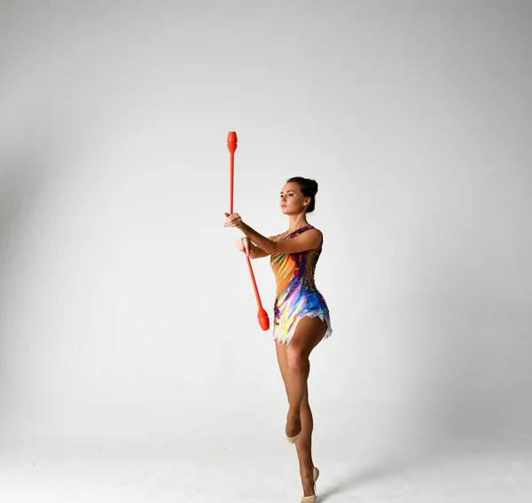 Gymnastka Jasném Obleku Tančí Červenými Holemi — Stock fotografie