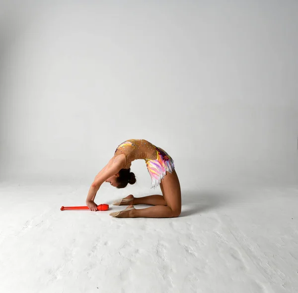 身穿鲜艳西服的体操运动员与红杆共舞 — 图库照片
