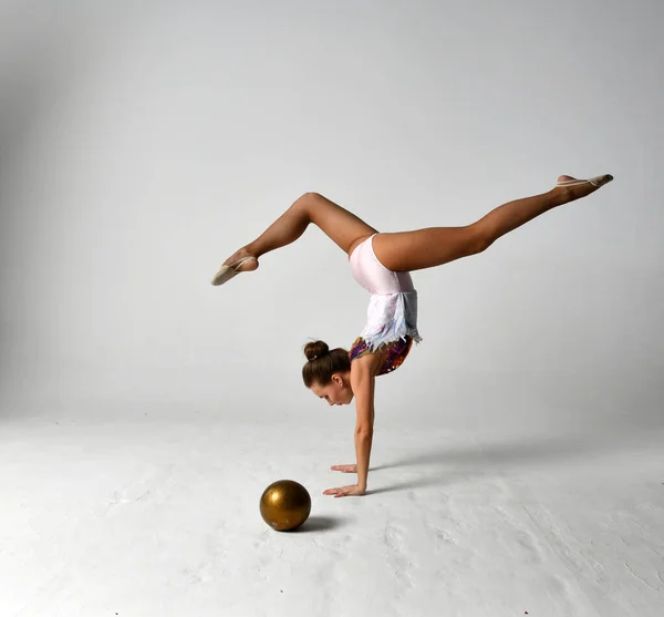 Ginasta Terno Brilhante Joga Uma Bola Ouro Fundo Branco — Fotografia de Stock