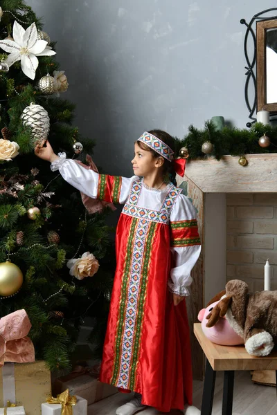 新年の木の近くの民族衣装の美しい女の子 — ストック写真