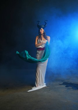 Beyaz elbiseli güzel bir kadın duman içindeki toprak tanrıçası yağmurda pareo ile dans ediyor.