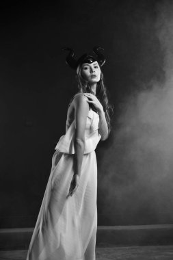 Toprak Tanrıçası 'nın kırmızı elbisesi içindeki güzel kadın dumanın içinde yağmurda dans ediyor.