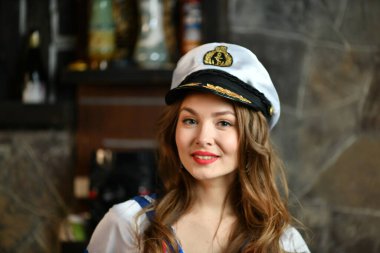 Üniformalı güzel bir kız ve gemi kaptanı şapkası.