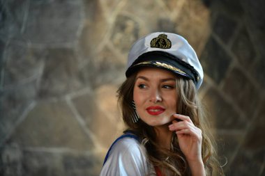 Üniformalı güzel bir kız ve gemi kaptanı şapkası.