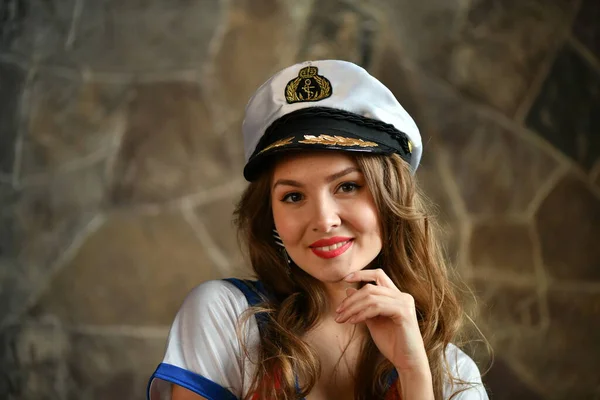 beautiful girl in a marine uniform and a cap of a ship captain