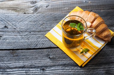 Taze pişmiş kruvasanlar peçete üzerinde çay ile.