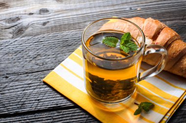 Taze pişmiş kruvasanlar peçete üzerinde çay ile.