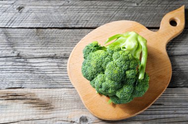 Ahşap kesme tahtası üzerinde taze yeşil brokoli demet