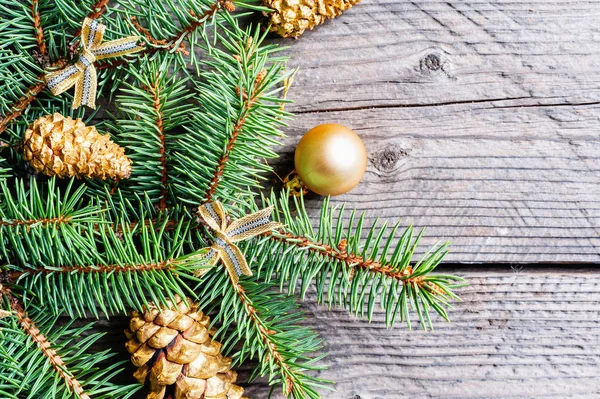 Karácsonyfa ágai arany golyó és fenyő kúp — Stock Fotó