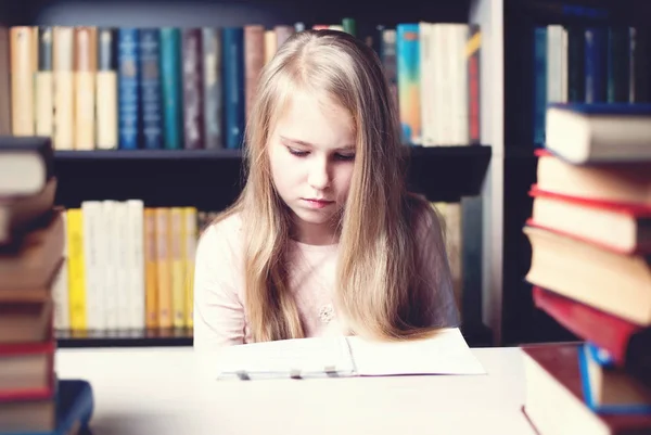 Petite élève fille étudier et lire livre à l'école — Photo