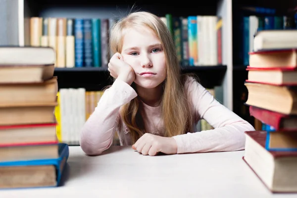 Fatigué et fatigué écolière étudier avec une pile de livres — Photo