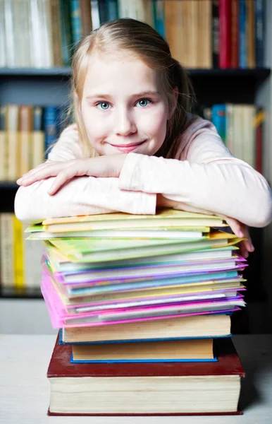 Beautiful smiling student with pile of books Royalty Free Stock Photos
