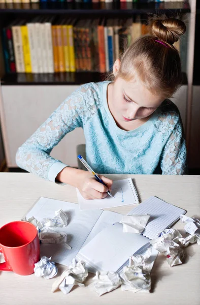 Schoolgirl sitting at table with pencil in hand. — Stock Photo, Image