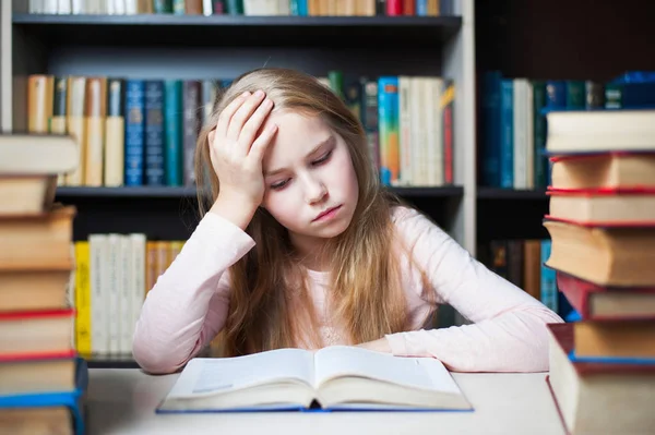 Colère et fatigué écolière étudier avec une pile de livres — Photo