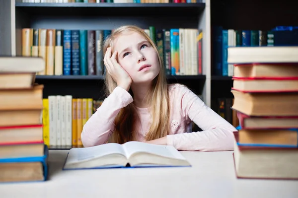Petite fille pensant ou rêvant pendant la préparation des devoirs — Photo