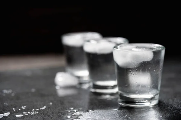 Coups de vodka avec glaçons sur pierre noire , — Photo