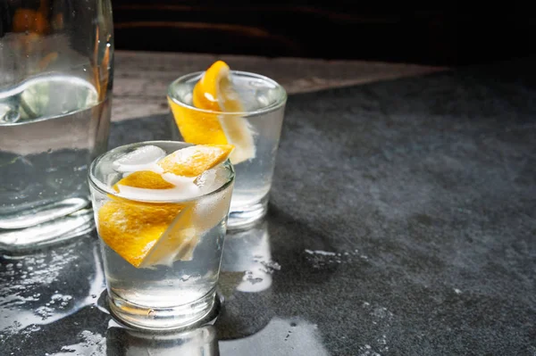 Bouteille de vodka avec verres et citron . — Photo