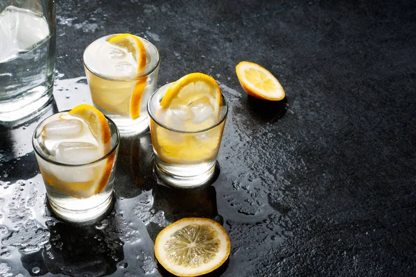 Bouteille de vodka avec verres et citron . — Photo