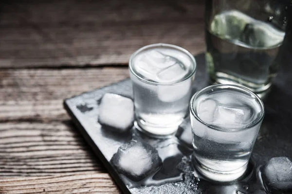 Vodka com gelo em copos de tiro — Fotografia de Stock