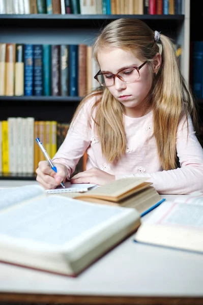 Petite fille intelligente avec des lunettes écrit sur le livre , — Photo