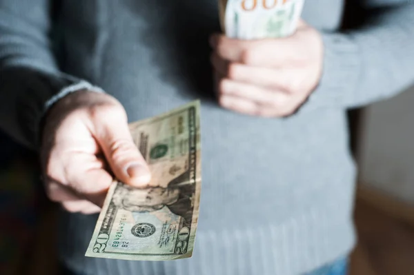 Homem dando-nos nota de dólar e segurando dinheiro nas mãos . — Fotografia de Stock