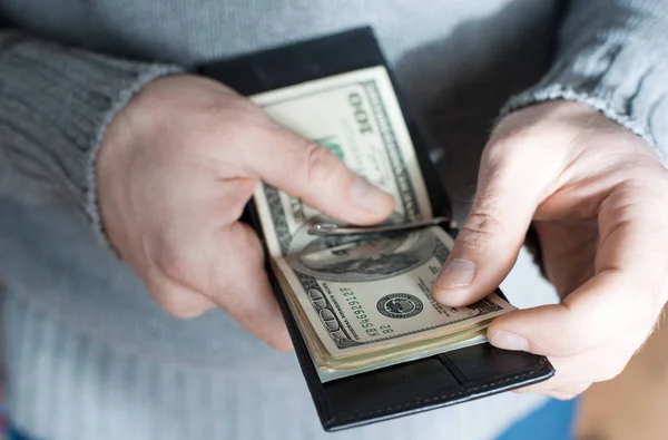 Hands holding us dollar bills and open wallet or pouch. — Stock Photo, Image