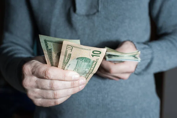 Homem dando-nos nota de dólar e segurando dinheiro nas mãos . — Fotografia de Stock