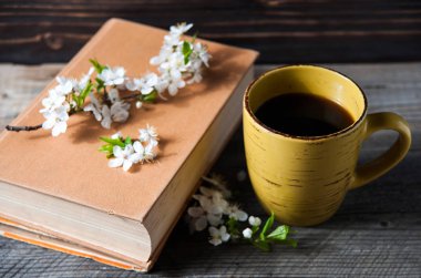 Bir fincan kahve ve hoş çiçek ile tahta arka plan ile ilgili bir kitap