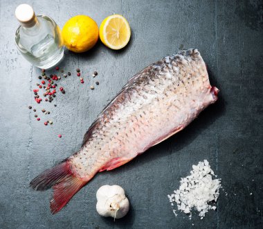 Sağlıklı gıda, diyet veya pişirme kavramı, seçici odak için vintage koyu arka plan üzerinde lezzetli taze balık sazan