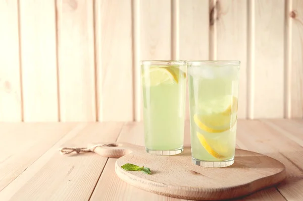 Citrus lemonade water with lemon sliced , healthy and detox water drink in summer on wooden table . vintage color tone — Stock Photo, Image