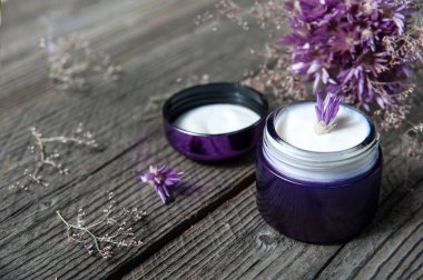 Kozmetik yüz kremi şişe ve menekşe çiçek