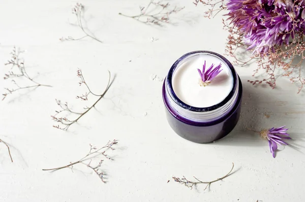 Crema cosmética y flores de lavanda sobre fondo de mesa de madera blanca — Foto de Stock