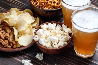 Ahşap masa - Kuruyemiş, cips ve patlamış mısır kase yemek için hazır bira snacks.