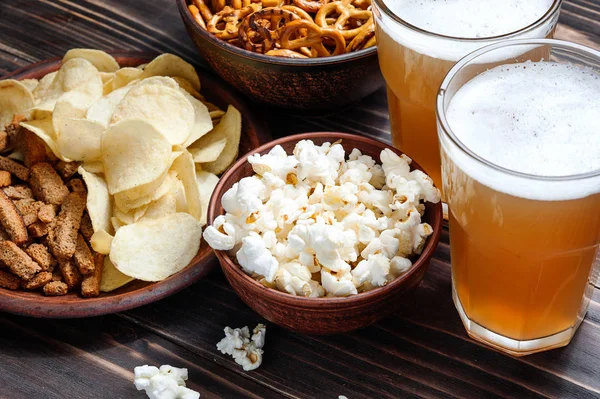 Ahşap masa - Kuruyemiş, cips ve patlamış mısır kase yemek için hazır bira snacks.