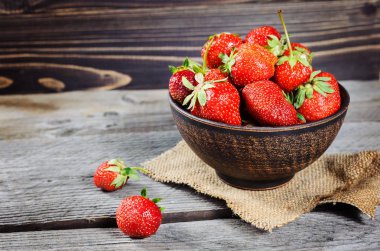 Eski ahşap arka planda taze çilekler.