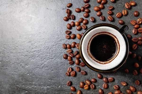 Filiżanka kawy z ziaren kawy na kamieniu stół tło — Zdjęcie stockowe