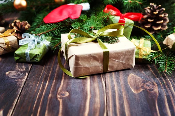 Sok karácsonyi ajándékok az asztalon a háttérben egy karácsonyfa — Stock Fotó
