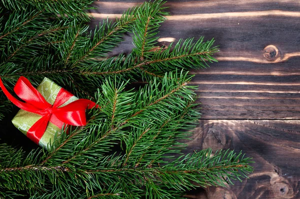 Boże Narodzenie pudełko. Prezenty z czerwoną wstążką w ciemny drewniany stół z choinki. Miejsce. — Zdjęcie stockowe
