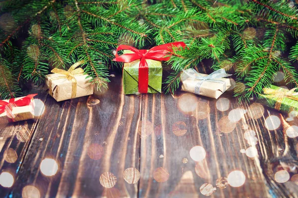 Karácsonyi díszdobozban. Karácsonyi ajándékokat, sötét fából készült asztal karácsonyfa piros szalaggal. Másolja a hely. — Stock Fotó