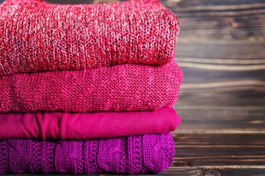 Tahta bir masanın üzerinde yatan sıcak örme giyim yığını