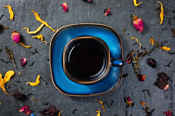 Cup of tea with herbs and flowers on stone background — Stock Photo, Image