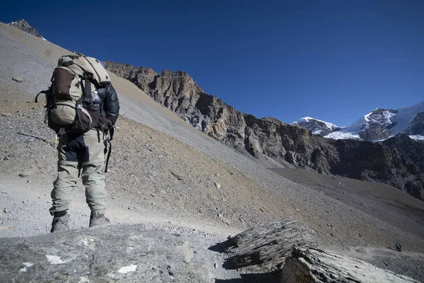 Trekker walking on mountain with mountains