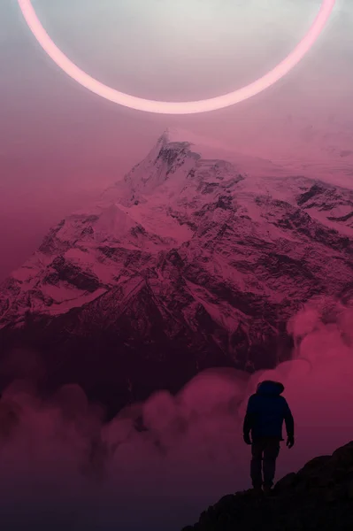 Dağın önünde duran adam. Geceleri pembe tonlarda gelecekten gelen bir manzara. Arkaplanda dağlar.