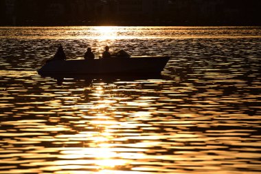 Akşam güneşinde Traunsee Gölü 'nde bir tekne (Gmunden; Salzkammergut; Yukarı Avusturya; Avusturya; Avrupa;)