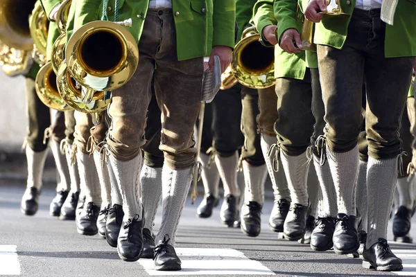 Deri pantolonlu bir bando adım atar. Deri pantolon genellikle kısa ya da uzun deri pantolonun adıdır. Deri pantolon, Avusturya ve Bavyera 'da geleneksel deri pantolonlardan daha yaygındır..