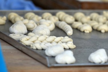 Pasta parçaları bir yemek tepsisi üzerinde şekillenir..
